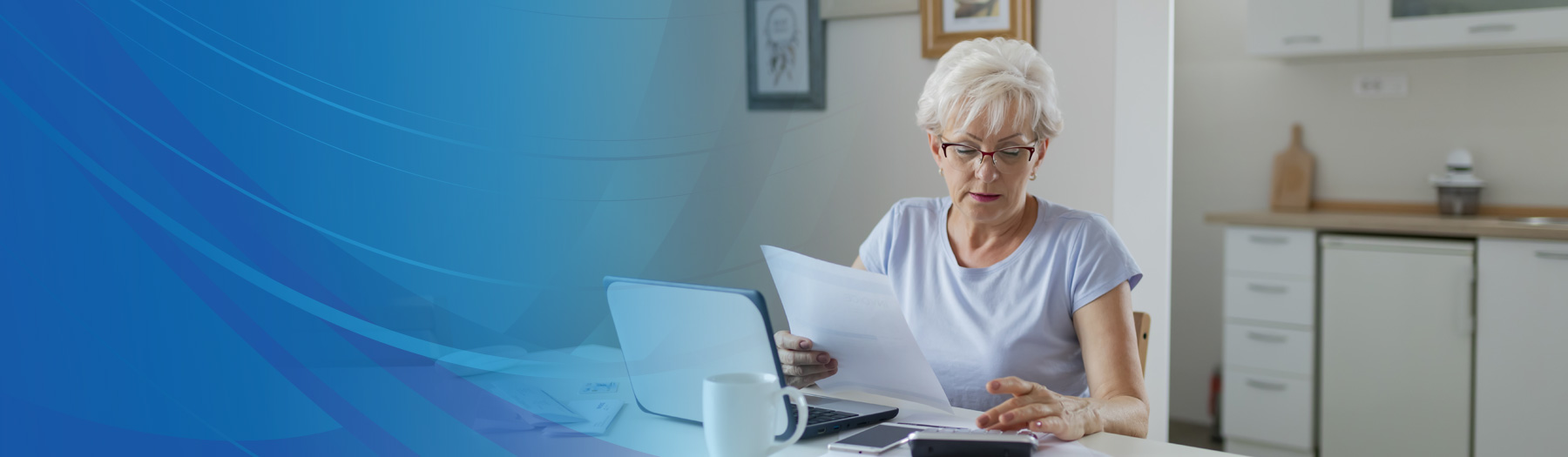 Older woman sitting at home examining papers