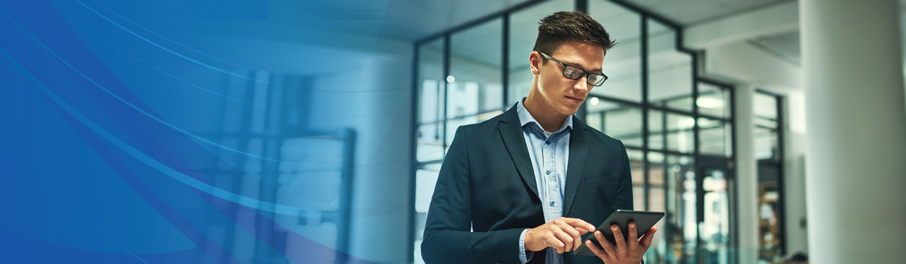 Male business owner checking his phone in an office lobby