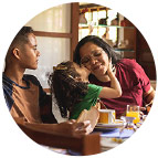 Hispanic mother at the breakfast table with her two children