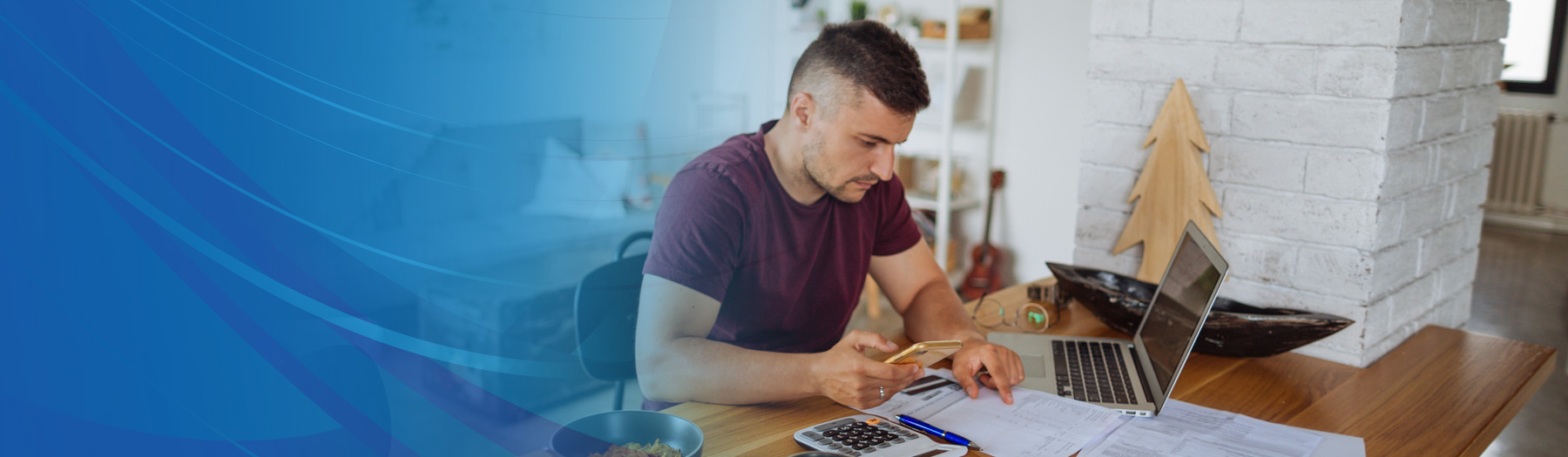 Man looking over financial documents with computer