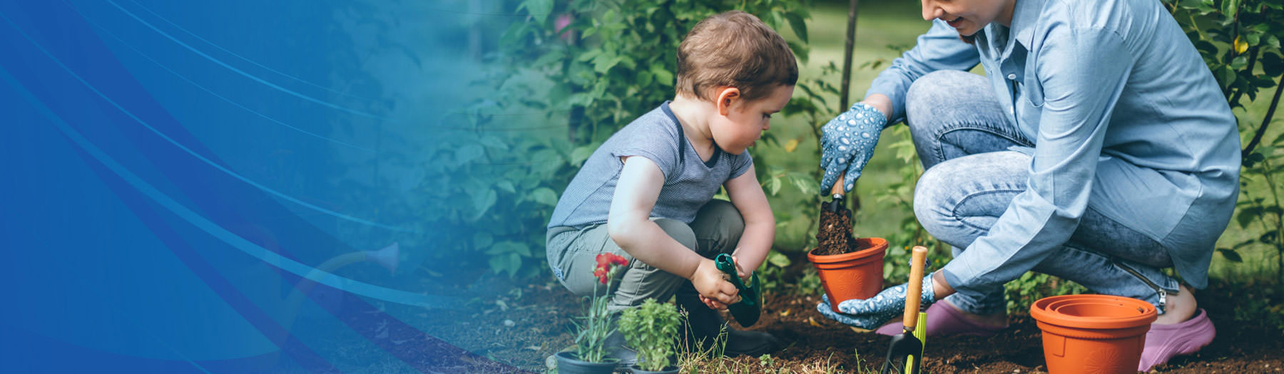 Parent and small child planting seeds in flowerpots near a garden