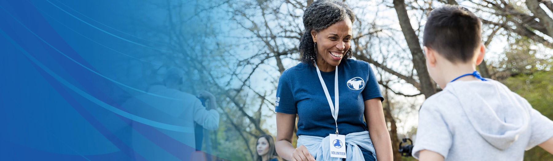 Female, non-profit volunteer talking with a young boy