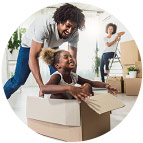 African American father pushing his little girl in a cardboard box across the floor