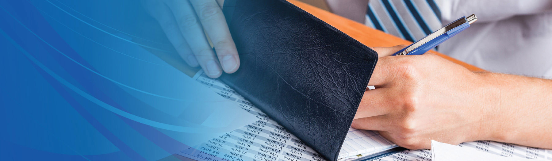 A person using a pen to write a check in a wallet-style checkbook