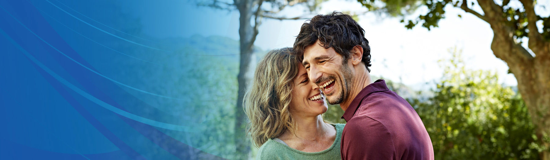 Man and woman standing close together and laughing outside