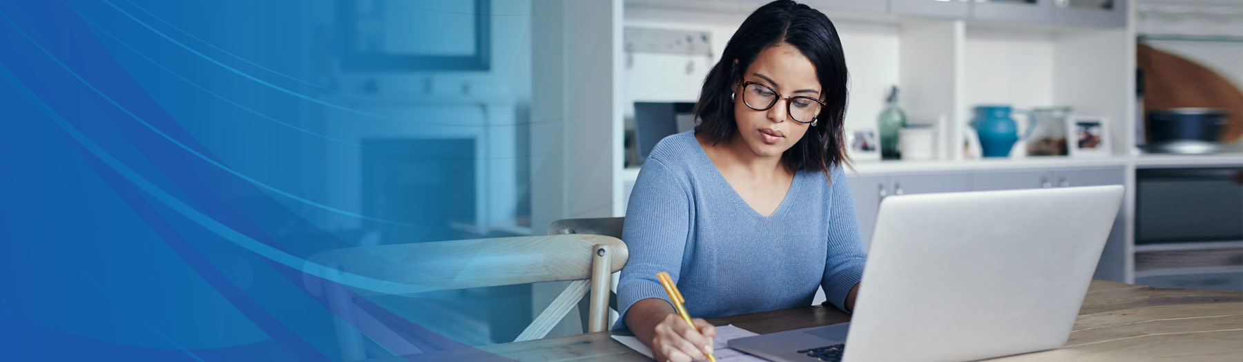 Young Hispanic woman with glasses using online banking on her laptop